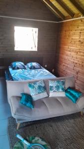 um quarto com uma cama e um sofá com almofadas em LES HAUTS DE L'ANSE em Bouillante