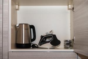 una macchinetta del caffè seduta su uno scaffale in cucina di DOMVS Ginori Testaccio a Roma