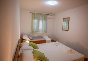 a room with two beds and a window at Apartments Plenković in Stari Grad