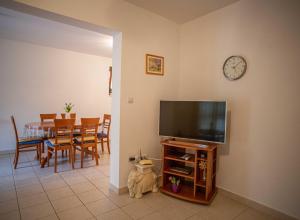 a living room with a television and a table with chairs at Apartments Plenković in Stari Grad