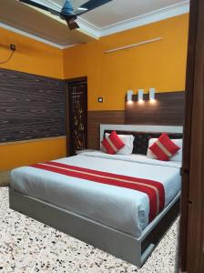 um quarto com uma cama grande e almofadas vermelhas em Star VIP-Inn Kolkata Airport em Calcutá