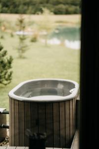 bañera de hidromasaje en un porche con vistas a un patio en IKnamai - namelis dviems, en Sakiniai