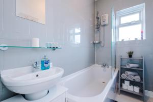 a white bathroom with a sink and a shower at Entire house in Dukinfield in Dukinfield