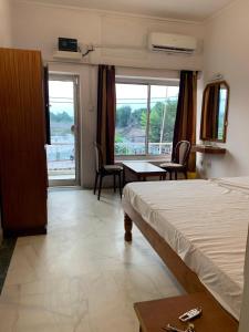 1 dormitorio con 1 cama, mesa y sillas en Hotel Lakeside en Khajurāho
