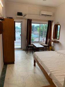 a bedroom with a bed and a table and chairs at Hotel Lakeside & Hostel in Khajurāho