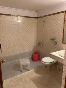 a bathroom with a toilet and a sink and a tub at Hotel Lakeside in Khajurāho