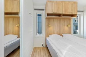 2 letti in una piccola camera con armadi in legno di Kosterbaden a Nedre Kile