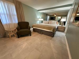 een slaapkamer met een bed, een stoel en een spiegel bij Nautilus 1702 Gulf Front Large 2 Bedroom Penthouse 7th Floor in Fort Walton Beach
