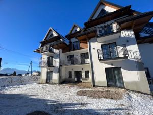 un gran edificio blanco con balcones. en Willa Janowa, en Bukowina Tatrzańska