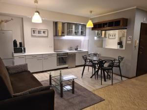 a kitchen and living room with a table and chairs at Wigwam Apartament 6-osobowy in Sopot