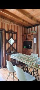 a dining table and chairs in a room with wooden walls at Refugio de bosque altos de ñancul in Panguipulli