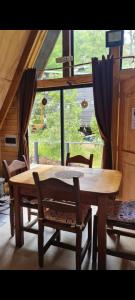 a wooden table and chairs in a room with a window at Refugio de bosque altos de ñancul in Panguipulli