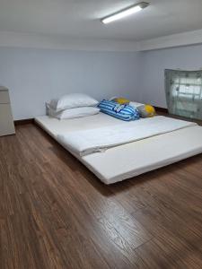 un grande letto bianco in una camera con pavimento in legno di Hieu House , 2 bedrooms 3 beds ad Ho Chi Minh