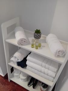 une étagère blanche remplie de serviettes et de serviettes dans l'établissement PERLA PREMIUM APARTMENT, à Timişoara