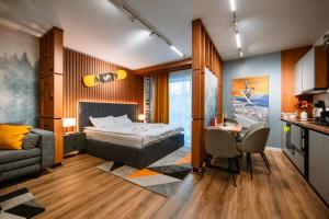 a bedroom with a bed and a table and a couch at Blue Sky Studio with pool and spa in Sinaia +45 photos