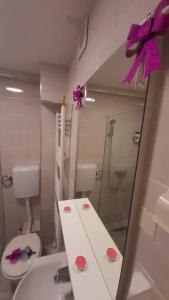 een badkamer met een spiegel, een wastafel en een toilet bij Apartman MiSSS in Pale