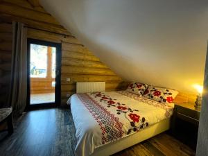 1 dormitorio con 1 cama en una cabaña de madera en Cabana Butura, en Negulesti
