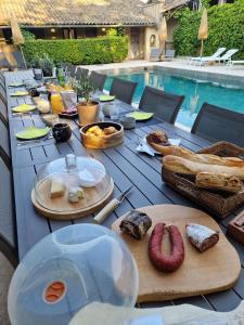 een tafel met eten naast een zwembad bij Le Mas de Mougins in Mougins