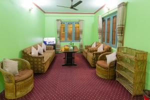 un soggiorno con divani, sedie e un tavolo di Paradise Boutique Hotel a Pokhara