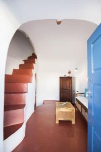 Cette chambre dispose d'un escalier avec une table et une porte. dans l'établissement Lioyerma Windmill Villa With Outdoor Hot Tub, à Oia