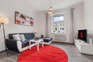 Air-conditioned Home Apartment Old Town في براتيسلافا: غرفة معيشة مع أريكة وسجادة حمراء