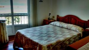 a bedroom with a bed and a window at Apartamento turístico en Porto do Son in Porto do Son