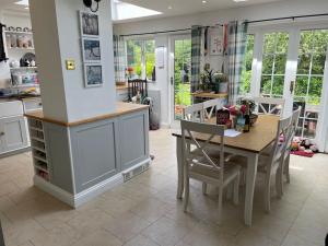 cocina y comedor con mesa y sillas en Lovely Charmouth cottage with log fire & garden close to beach, en Charmouth