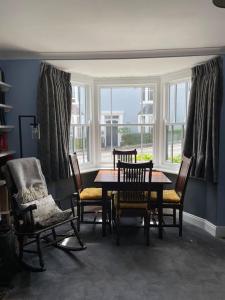 a dining room with a table and chairs and a window at Lovely Charmouth cottage with log fire & garden close to beach in Charmouth
