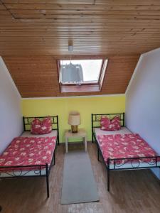 two beds in a room with a window at Gemeinschaft Ferienhaus in Bad Neuenahr-Ahrweiler