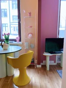 a dining room with a table and a yellow chair at Värikäs koti lähellä keskustaa in Helsinki