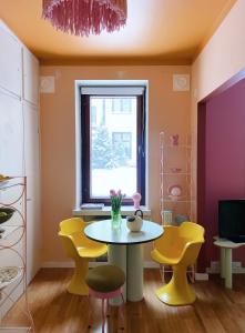 a dining room with a table and yellow chairs at Värikäs koti lähellä keskustaa in Helsinki