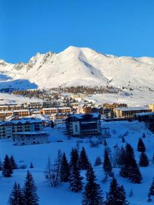a town covered in snow with a mountain in the background at Bella Mapi in Passo del Tonale