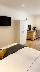 a bedroom with a bed with a television on the wall at Chambre le Petit Olivier in Arles