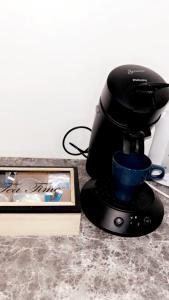 a coffee maker sitting on a counter next to a book at Chambre le Petit Olivier in Arles