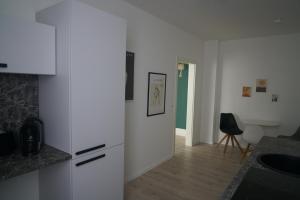 uma cozinha com armários brancos e uma porta verde em Apartment Carla em Senftenberg