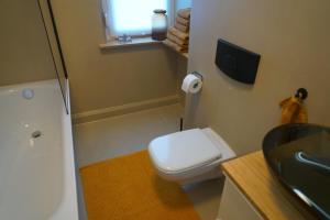a bathroom with a white toilet and a sink at Apartment Carla in Senftenberg