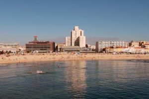 a group of people in the water at a beach at Hotel Apartamento Solverde in Espinho