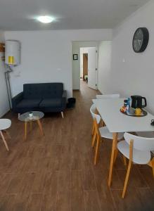 a living room with a couch and a table and chairs at Hotel Tabancura in Copiapó