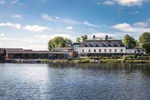 un grande edificio bianco accanto a un corpo d'acqua di Hooks Herrgård a Hok