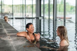 Deux femmes dans l'eau d'une piscine dans l'établissement Hooks Herrgård, à Hok