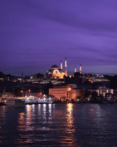 a city lit up at night with a river at Union Hotel Karaköy in Istanbul