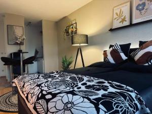a bedroom with a black and white bed and a lamp at Willkommen im „happines(t)“ in Haslach