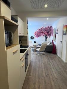 a kitchen with a living room with a tree in the window at Ferienwohnung zwischen Wald und Wasser in Berlin