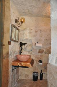a bathroom with a bowl sink on a stone wall at cemil köyü cave house in Ürgüp