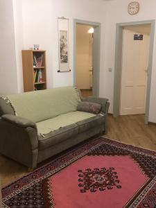 a living room with a couch and a rug at Marktresidenz Eisenach- Stilvolle Maisonette mit 3 Zimmern und 2 Bädern in Eisenach