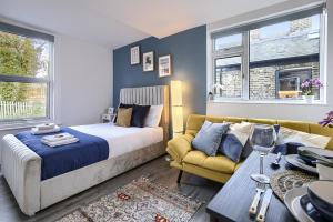 a bedroom with a bed and a couch and windows at Hackney Central Deluxe Apartment in London