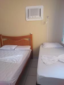 a room with two beds and a air conditioner at Casa na Ilha da Crôa/Barra de Santo Antônio in Barra de Santo Antônio