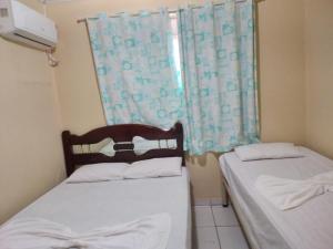 deux lits dans une petite pièce avec une fenêtre dans l'établissement Casa na Ilha da Crôa/Barra de Santo Antônio, à Barra de Santo Antônio 17 autres photos