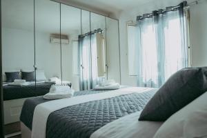 a bedroom with two beds and a large mirror at [Attico in Centro - Crotone] appartamento elegante in Crotone