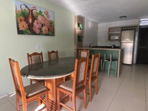 een keuken en eetkamer met een tafel en stoelen bij Casa Praia Perola in Passo de Torres